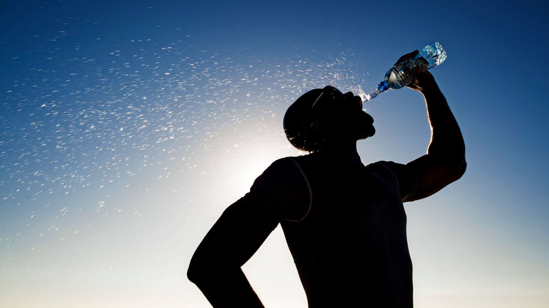 athlete drinking water after finishinh his run